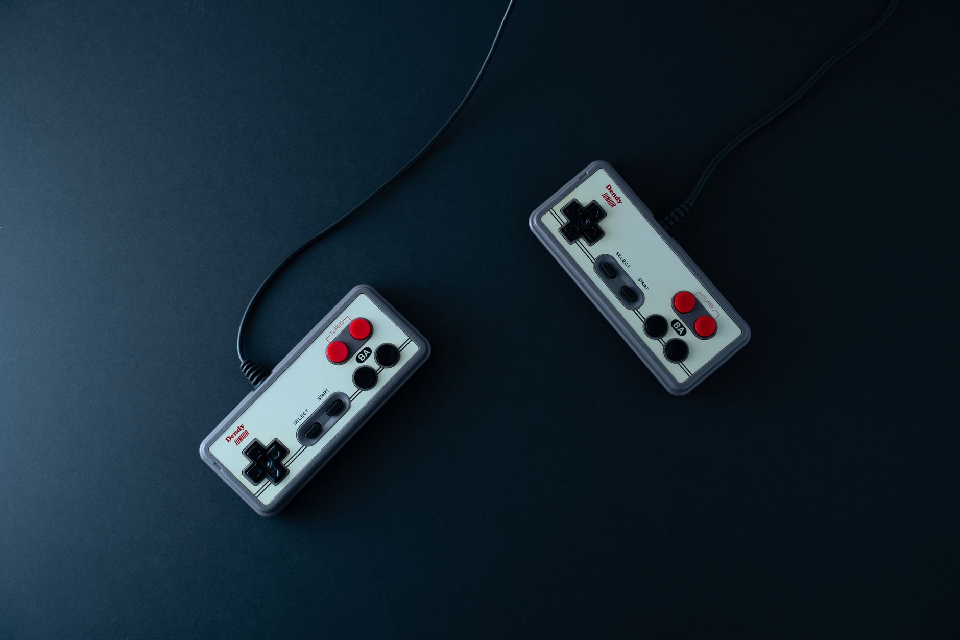 Hands playing console controller in retro room setting