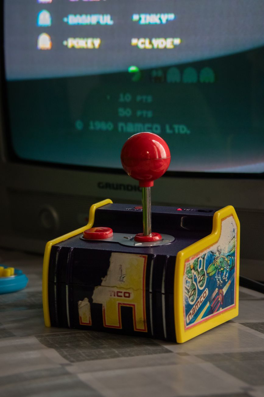 Retro television set in dark room with controllers